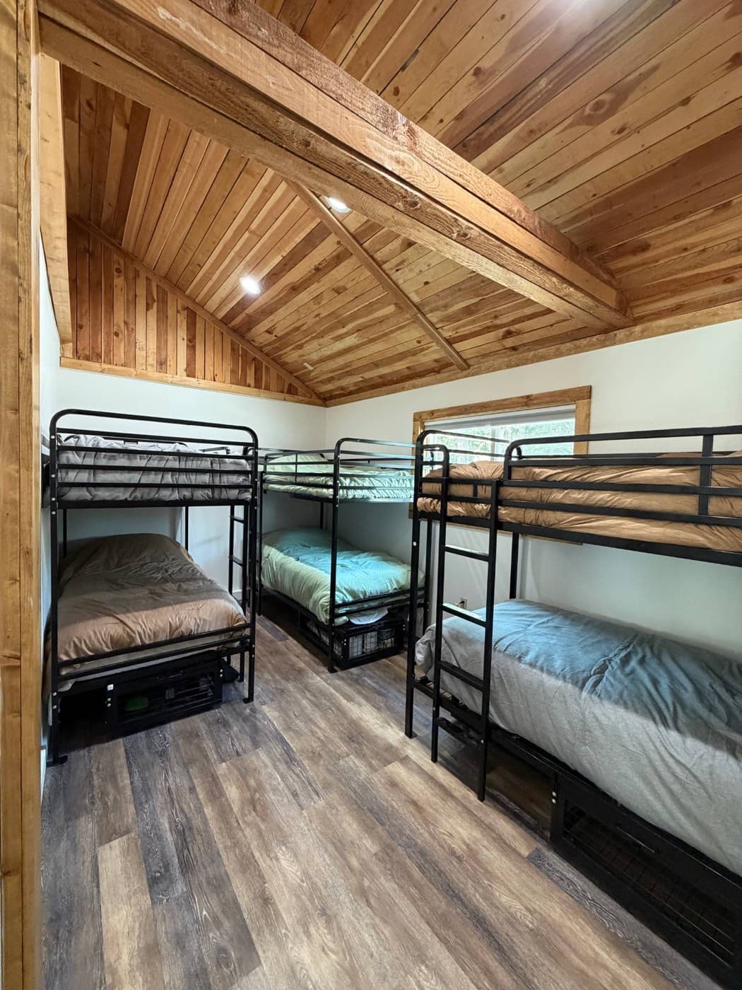 Bunk beds with linens made up in a shared bunkroom at the Wallowa Lake Pack Station bunkhouse
